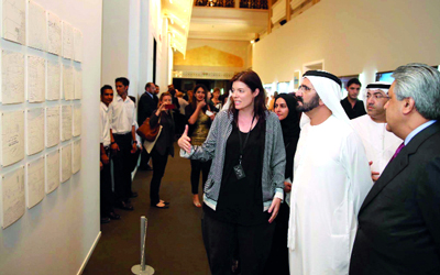 سموه يستمع إلى إيجاز حول أحد الأعمال الفنية. وام