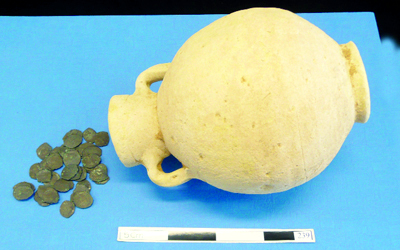 جرة فيها مسكوكات.من المصدر