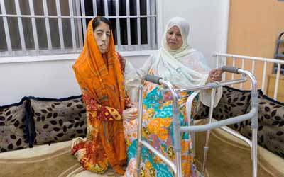 سميّة مع والدتها في منزل غير مهيأ لإعاقتها الحركية.  تصوير: أحمد عرديتي