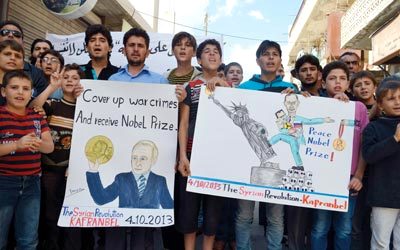 تظاهرة في بلدة كفرنبل بريف إدلب تنتقد تقديم الغطاء الدولي للأسد بعد قتله 115 ألف شخص.  أ.ف.ب