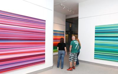 مراد يعمد إلى تقسيم اللوحات لأجزاء لونية بأسلوب تجريدي يقوم على التقطيع الأفقي، متعمداً التكرار في مزيج الألوان التي يختارها لكل عمل. تصوير: أشوك فيرما