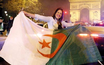 جزائرية تحتفي بتأهل الخضر في العاصمة الفرنسية باريس. أ.ب