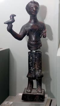 تمثال من البرونز لرجل يحمل طيراً معروض في متحف الشارقة للآثار.