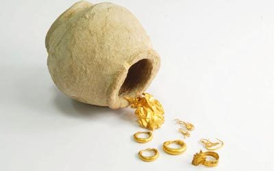 جرة فخارية قديمة عُثر عليها وبداخلها قطع أثرية صغيرة وذهبيات مختلفة.