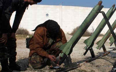 مقاتل من الجيش السوري الحر يعد صاروخاً لإطلاقه باتجاه القوات النظامية في الغوطة الشرقية.  رويترز
