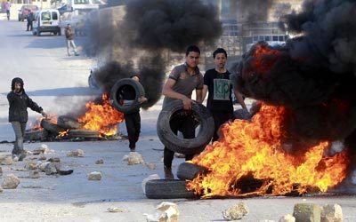فلسطينيون خلال مواجهات مع قوات الاحتلال بعد أن قامت الأخيرة بهدم مصانع قرب الخليل. إي.بي.إيه