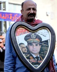 مصري يرفع صورة السيسي لترشيحه للرئاسة لمواجهة الإرهاب.  أ.ف.ب