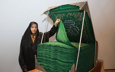 «قرآن الفجر» من المخمل الأخضر الذي تُصنع منه كسوة الكعبة المشرفة.    تصوير: نجيب محمد