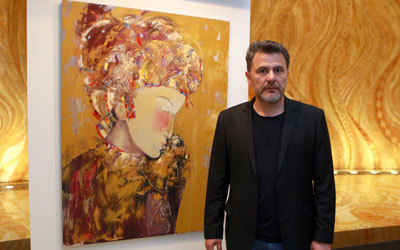 تيمور أحمدوف أمام أحد أعماله في المعرض.