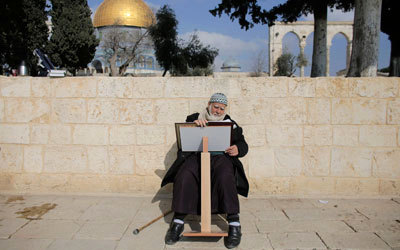 فلسطيني يقرأ القرآن الكريم أمام المسجد الأقصى حيث دارت اشتباكات مع متطرفين حاولوا اقتحامه.   رويترز