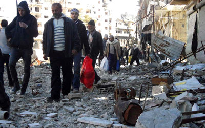 مدنيون يحملون أمتعتهم بانتظار إجلائهم من المنطقة المحاصرة في حمص القديمة.  رويترز