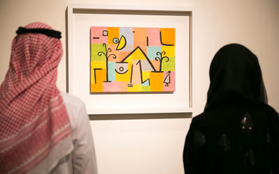 زائران يشاهدان لوحة «عذوبة الشرق» لبول كلي في معرض «نشأة متحف» الذي أقيم العام الماضي في أبوظبي بمنارة السعديات بالقرب من موقع «اللوفر أبوظبي» المرتقب.  من المصدر