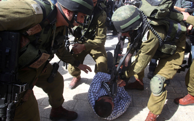 جنود إسرائيليون يضربون أحد المحتجين الفلسطينيين.  أ.ف.ب