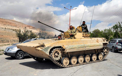 صورة بثتها وكالة «سانا» تظهر جنوداً من القوات النظامية على دبابتهم خلال دورية في معلولا.  أ.ب