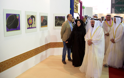 سلطان القاسمي يطلع على أعمال مشاركة في المعرض أول من أمس.  الإمارات اليوم
