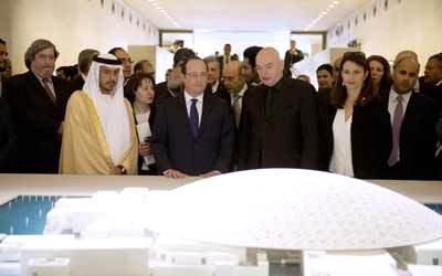 سلطان بن طحنون وفرانسوا هولاند وشخصيات ثقافية أمام مجسم للمتحف الذي يعتبر واحدة من العلامات الثقافية في العالم. ا.ف.ب