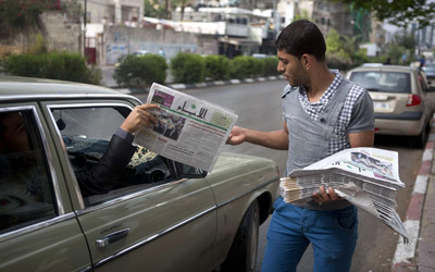 بائع خلال توزيع صحيفة «الأيام» بعد دخولها غزة.     أ.ف.ب