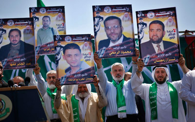 هنية يرفع صورة أحد الأسرى خلال مسيرة في غزة للتضامن مع المعتقلين الإداريين المضربين عن الطعام. رويترز