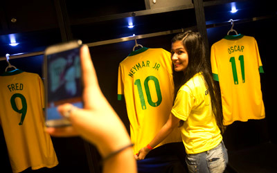 فتاة برازيلية تلتقط صورة مع قميص نجمها المفضل نيمار استعداداً للمونديال.   أ.ف.ب