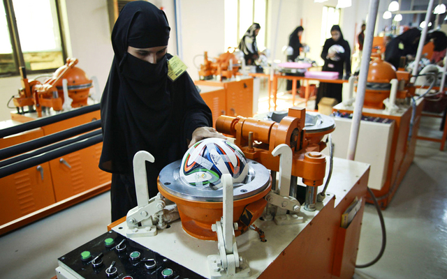 إحدى العاملات في مصنع باكستاني خلال تصنيع كرة «برازوكا». أرشيفية