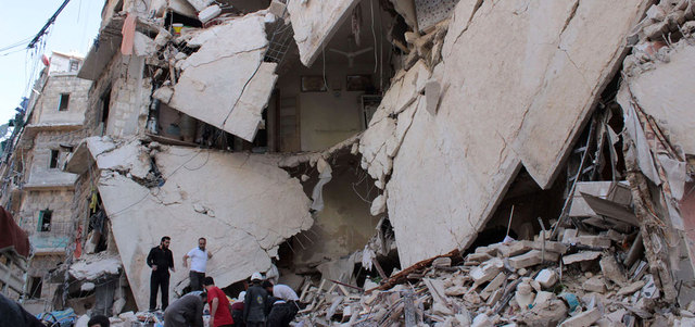 سوريون يبحثون عن ناجين بين أنقاض منازل تهدمت بقصف للقوات النظامية على حي بستان القصر في حلب.  أ.ف.ب