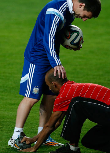 أحد المشجعين يلمع حذاء ميسي خلال تدريبات الأرجنتين. أ.ب