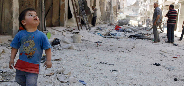 صبي يمشي بجانب الحطام الناجم عن قصف للقوات النظامية في حي طريق الباب بحلب. رويترز