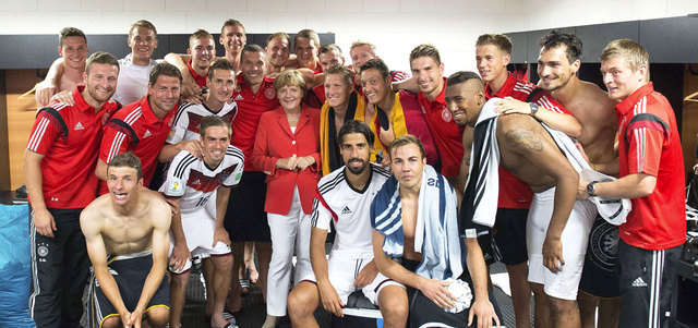 ميركل تحتفل مع اللاعبين بعد الفوز على البرتغال برباعية نظيفة. أ.ف.ب