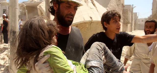عامل إنقاذ يساعد فتاة أصيبت بغارة للقوات النظامية على حي المرجة في حلب. أ.ف.ب
