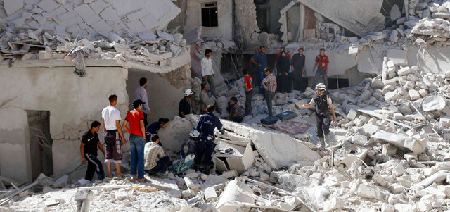 رجال إنقاذ يبحثون عن ناجين بين أنقاض المباني المنهارة ببرميل متفجر على حي الأنصاري في حلب.  رويترز