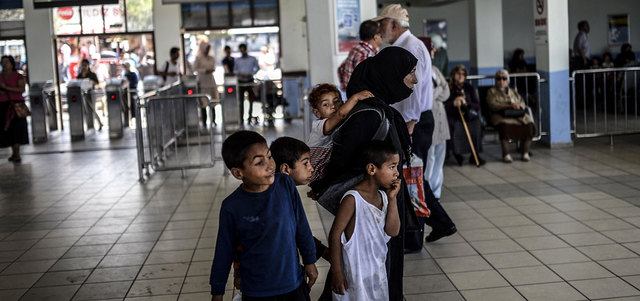 لاجئة سورية تنتظر العبارة مع أطفالها في أوسكودار، أحد أحياء اسطنبول. أ.ف.ب