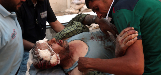 موظفو الطوارئ يسعفون رجلاً أصيب بقصف للقوات النظامية على حلب. أ.ف.ب