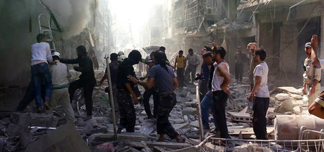 سوريون يبحثون عن ناجين وسط أنقاض مبانٍ دُمرت بقصف القوات النظامية على حي كرم الجبل في حلب. أ.ب