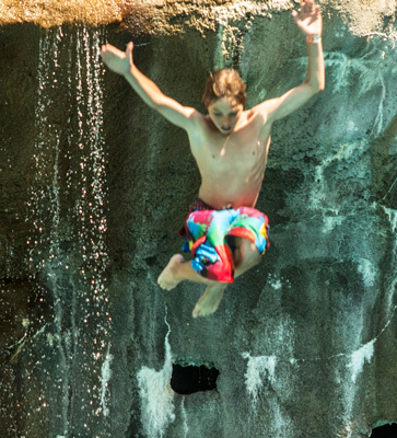 زائر يسقط من فوق ربوة مرتفعة وسط شلال المياه.