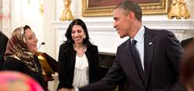 أوباما يرحب بإحدى المدعوات إلى إفطار سابق.