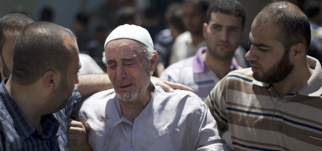 والد أحد الشهداء يبكي بحرقة في مستشفى الأقصى بدير البلح وسط غزة. أ.ف.ب