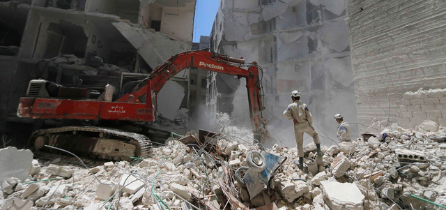 حفارة ترفع أنقاض مبانٍ دُمرت بإلقاء القوات النظامية برميلاً متفجراً على حي الفردوس في حلب. رويترز
