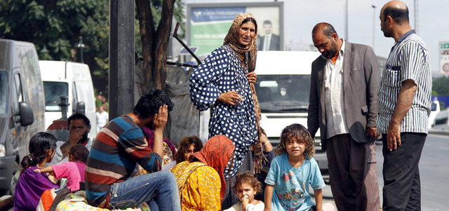 لاجئون سوريون يجلسون في حديقة عامة بحي الفاتح في إسطنبول بعد أن تقطعت بهم السبل.  إي.بي.إيه