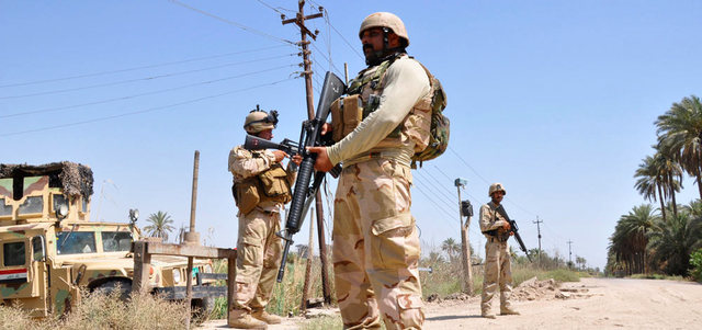 أفراد من قوات الأمن خلال دورية في بلدة جرف الصخر جنوب بغداد.  رويترز