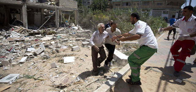 أحد أفراد الطواقم الطبية يحاول إجلاء سكان في غزة بعد تعرض منازلهم للقصف الإسرائيلي. أ.ف.ب