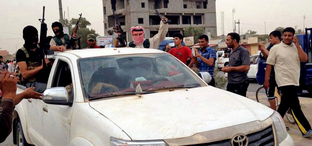 مسلحون من «ميليشيا إسلامية» في موكب بمدينة بيجي شمال العاصمة العراقية بغداد. أ.ب