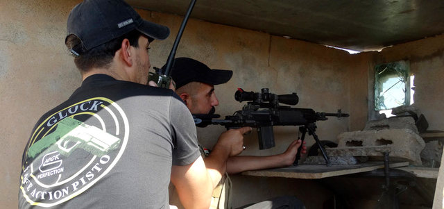 عنصرا أمن عراقيان يتخذان مواقعهما خلال اشتباكات مع مسلحي «داعش» في الرمادي. رويترز