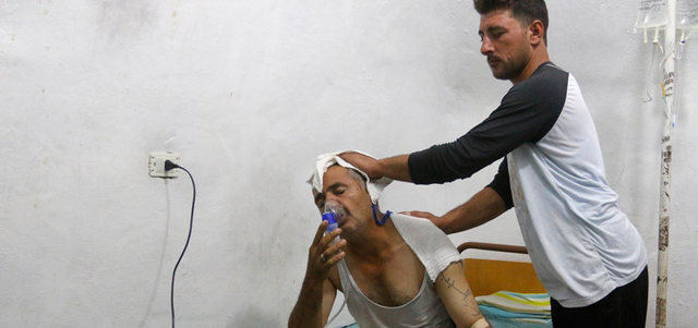 رجل يتنفس بوساطة قناع أكسجين في مستشفى بعد هجوم بالغاز على بلدة اللطامنة بريف حماة.  رويترز