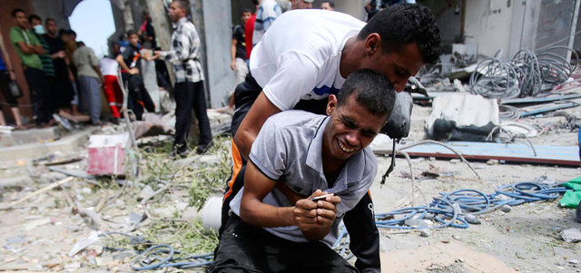 فلسطيني يبكي والدته عقب رفع جثمانها من تحت الأنقاض. رويترز