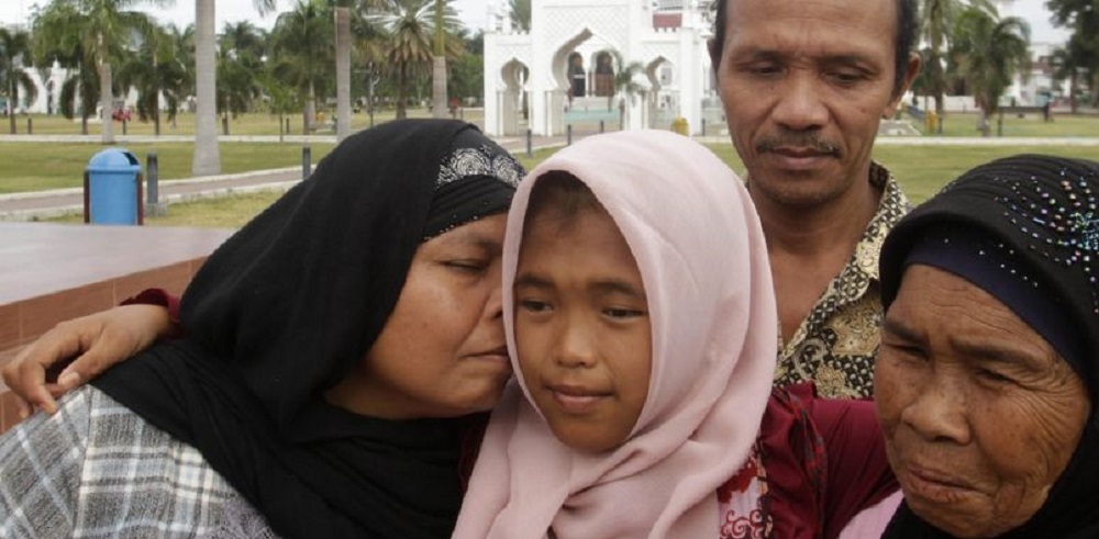 روضة الجنة تتوسط امها جمالية (يسار الصورة) والمرأة التي قامت بالاعتناء بها طوال الأعوام العشرة الماضية. رويترز