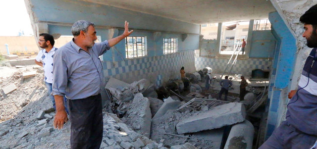 سوريون يزيلون الأنقاض لإعادة تشغيل محطة مياه الرقة التي استهدفت بغارة للقوات النظامية.  رويترز