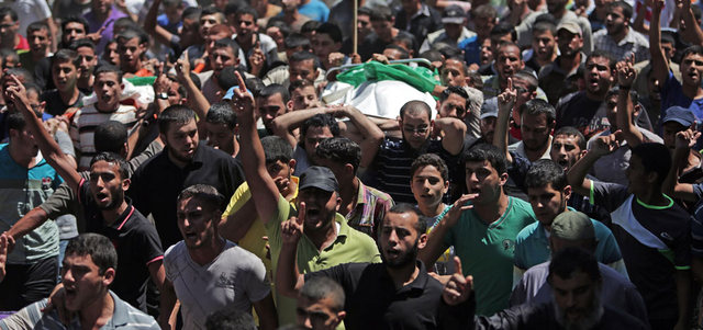 جماهير غفيرة بغزة شيّعت جثمان زوجة الضيف وابنه الرضيع.. وفي الإطار منزل عائلة الدلو بعد قصفه.   أ.ف.ب