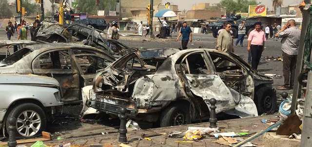مدنيون يتجمعون في موقع انفجار سيارة مفخخة تسبب في مقتل 5 أشخاص بمنطقة تجارية في بغداد الجديدة. أ.ب