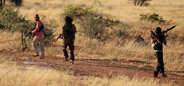 مقاتلون من الجيش الحر يدخلون بأسلحتهم بالقرب من نقطة تفتيش تابعة للجبهة الإسلامية في ريف إدلب.  رويترز