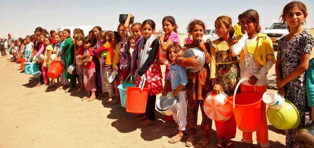نازحون إيزيديون من بلدة سنجار العراقية غرب الموصل، خلال تلقيهم المواد الغذائية في مخيم على مشارف محافظة دهوك. رويترز